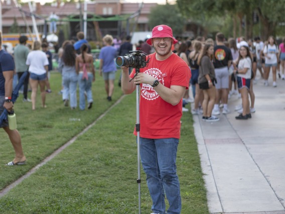 Destination Arizona Leader, Steven, smiling at the camera as he captures images of the Evening Oasis event. 