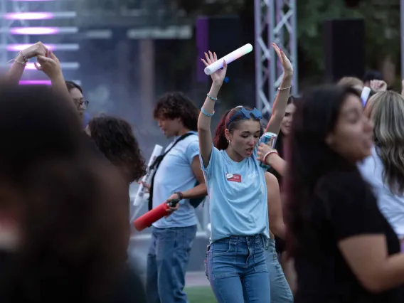 Destination Arizona Leader, Carolina, dances with her hands up and a LED light-up baton during Evening Oasis. 