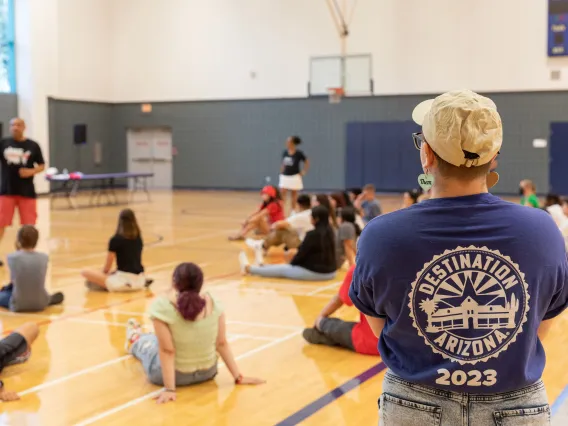 Destination Arizona Leader, KJ, overseeing students participate in an activity wearing their blue Destination Arizona 2023 staff shirt.
