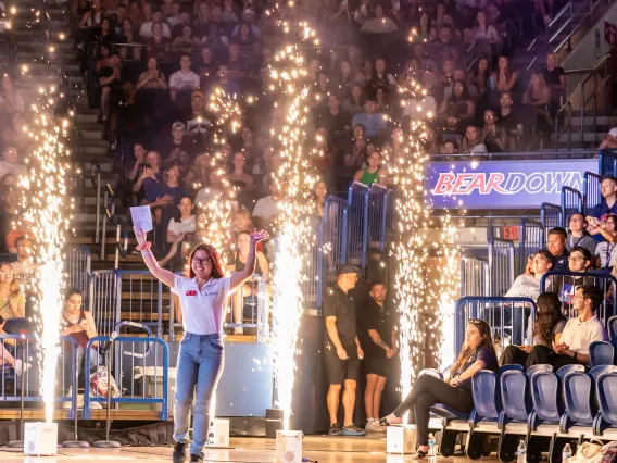 Destination Arizona Leader, Trin, smiling as they enter McKale Memorial Center through cold-spark fireworks. 