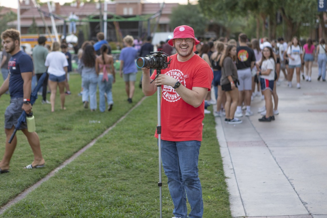 Destination Arizona Leader, Steven, smiling at the camera as he captures images of the Evening Oasis event. 