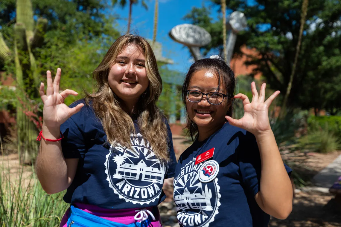 Destination Arizona Leaders, Karime and Chi, pose for the camera smiling with the cat claw. 