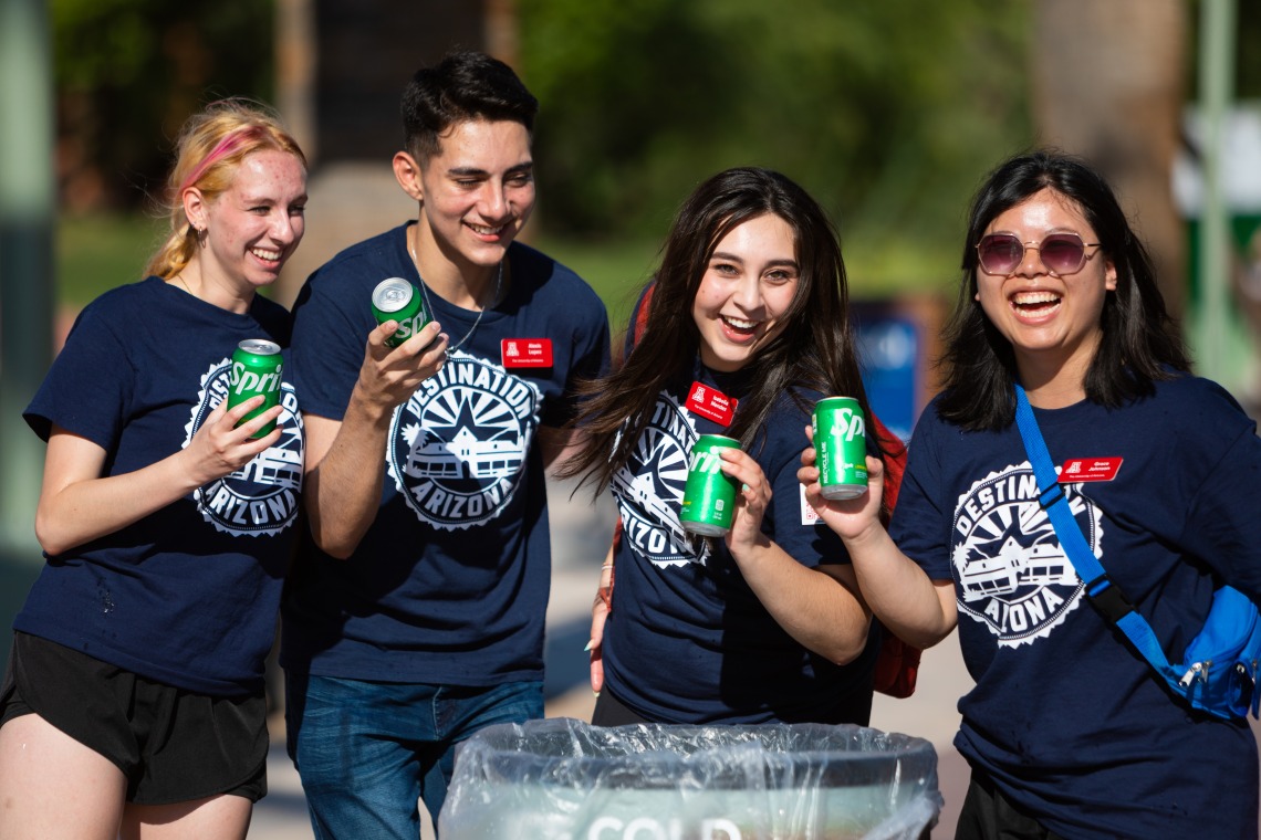 Destination Arizona Leaders, Niyah, Alexis, Isabella and Grace smile while passing out sodas to students