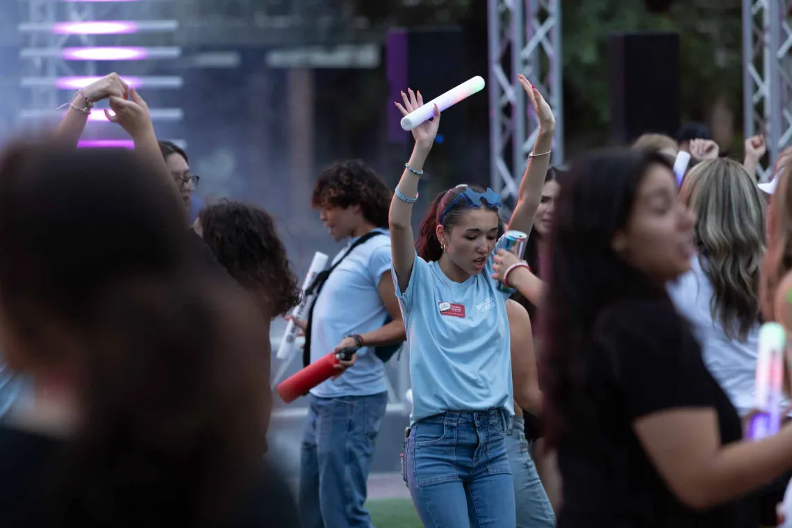 Destination Arizona Leader, Carolina, dances with her hands up and a LED light-up baton during Evening Oasis. 