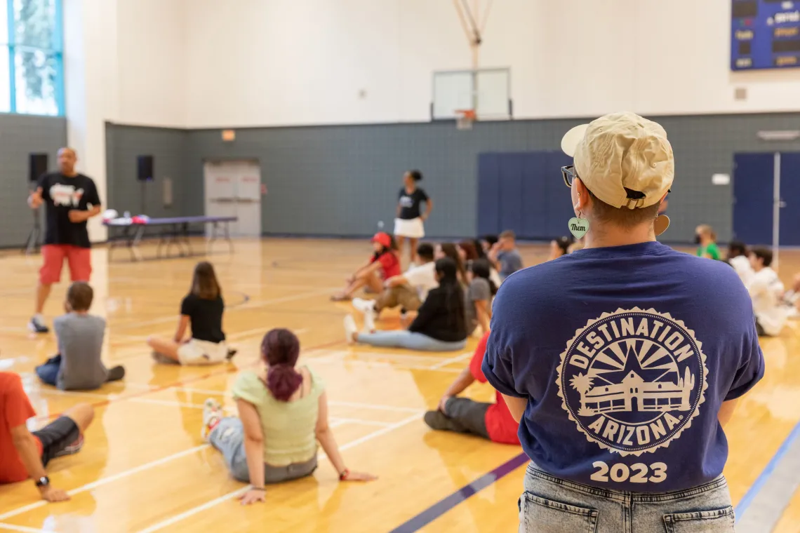 Destination Arizona Leader, KJ, overseeing students participate in an activity wearing their blue Destination Arizona 2023 staff shirt.